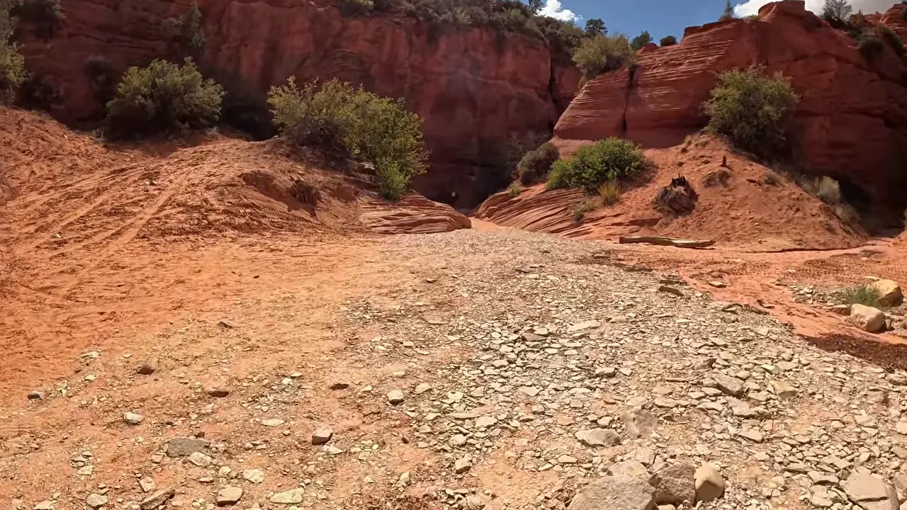 Entrance to Peek-A-Boo slot canyon showing narrow mouth and red sandstone
